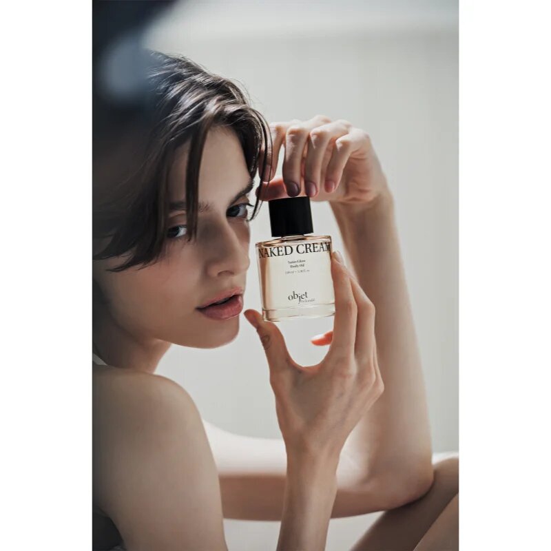 KUNDAL Objet Satin Glow Body Oil подхранващо масло за тяло за интензивна хидратация с аромат Naked Cream 100 мл.