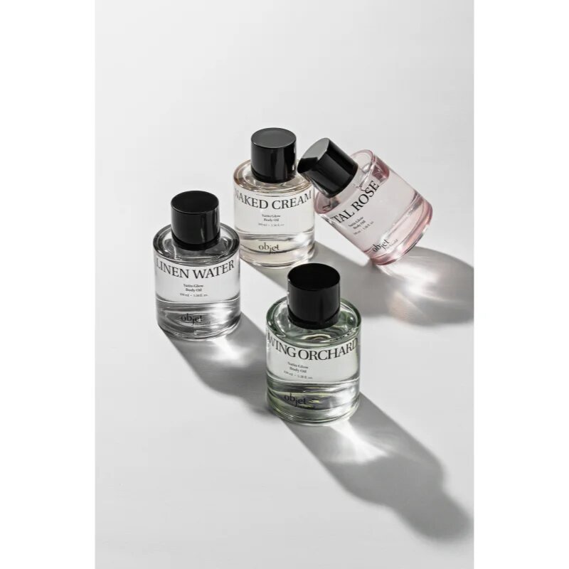 KUNDAL Objet Satin Glow Body Oil подхранващо масло за тяло за интензивна хидратация с аромат Santal Rose 100 мл.