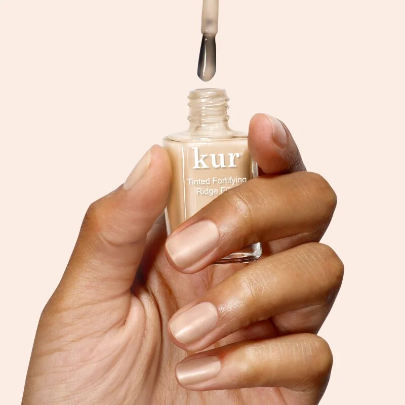 LONDONTOWN Kur Tinted Fortifying Ridge Filler изглаждаща основа-лак за нокти за сухи и крехки нокти цвят Apricot Beige 12 мл.